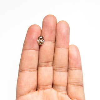 Oval champagne diamond held on hand on a white background