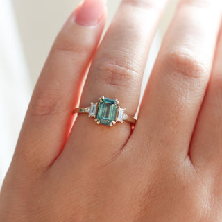 Emerald Cut Teal Sapphire Ring  worn on hand front view in sunlight