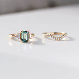 Emerald Cut Teal Sapphire Ring paired with diamond gold in sunlight