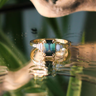 Misceo Emerald Cut Green Sapphire Ring on a mirror with reflections detailed front view