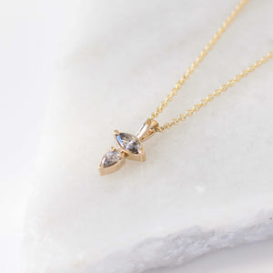 Marquise and pear cut diamond necklace in yellow gold on marble side view 