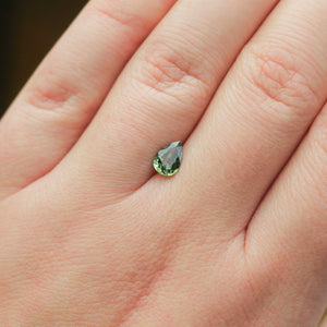 Pear shaped green sapphire on hand