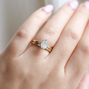 five diamond wedding band and oval diamond ring set on hand