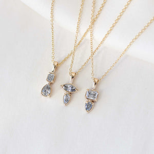 Emerald cut and pear diamond necklace in yellow gold paired with diamond gold necklaces detail view 