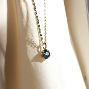 Blue sapphire necklace in yellow gold in sun light front view 