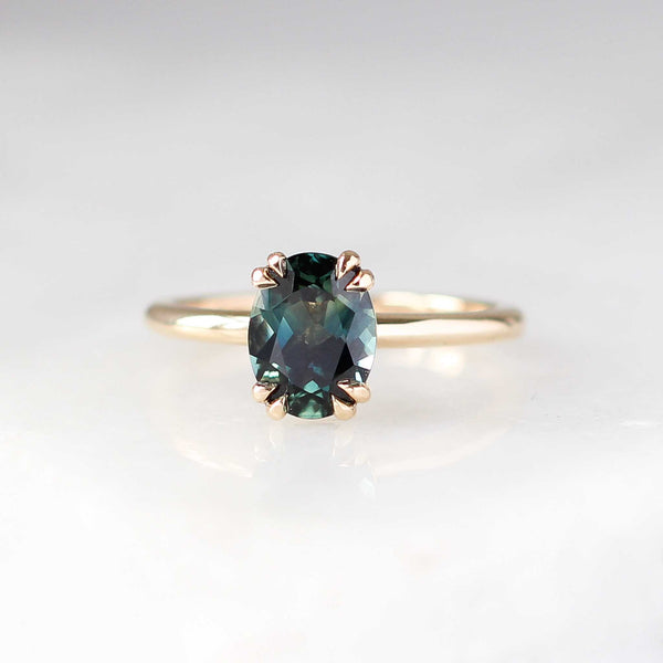 Oval cut green sapphire ring in yellow gold front view