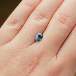Oval shaped teal sapphire on hand