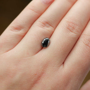 Oval shaped black diamond on hand