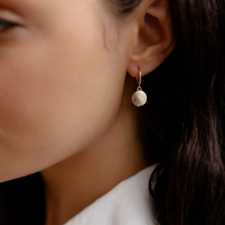 Golden drop earrings being worn