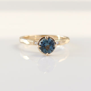Round blue spinel ring in yellow gold, front view