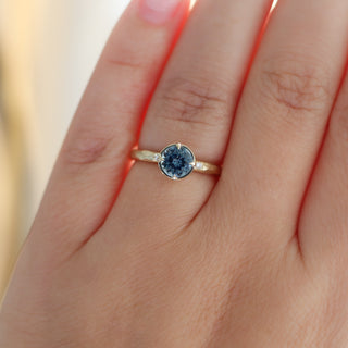 Round blue spinel ring in yellow gold, on hand