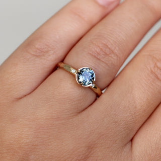 Round blue spinel ring in yellow gold, on hand