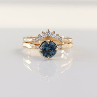 Round blue spinel ring in yellow gold stacked with curved diamond wedding band, front view