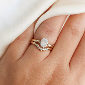Oval diamond ring with diamond crown on finger