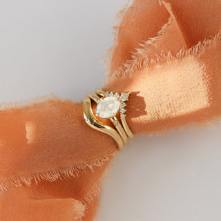 Oval diamond engagement ring with curved bands on fabric