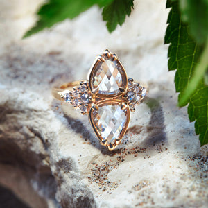 Double Pear Diamond Ring on stone with green leaves