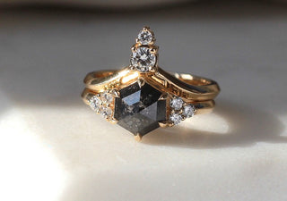 Black hexagon cluster ring with gold band and diamond accents.
