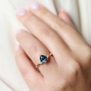 Pear blue sapphire engagement ring on hand