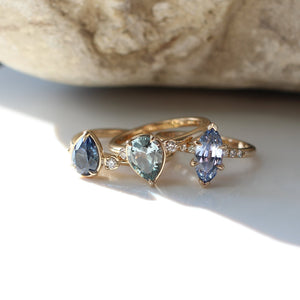 Pear blue sapphire engagement ring in sapphire and diamond ring group shot