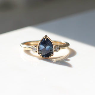 Pear blue sapphire engagement ring in sunlight