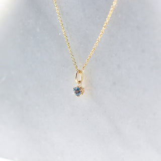 Blue Montana Sapphire Charm Necklace quarter view on marble