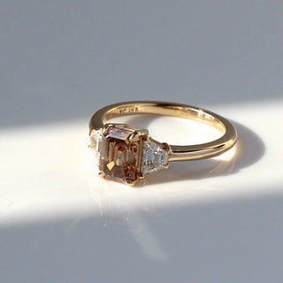 Custom engagement ring with ethically sourced brown emerald cut diamond centre stone in a gold setting.