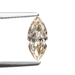 Champagne marquise cut diamond on white background, held by tweezers