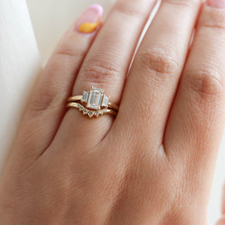 Emerald cut champagne diamond ring with curved band on hand