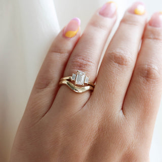 Emerald cut champagne diamond ring with fitted band on hand