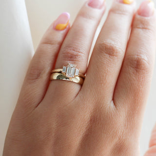 Emerald cut champagne diamond ring with wide band on hand