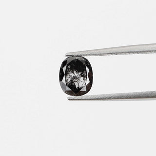 Cushion shaped salt and pepper diamond in tongs