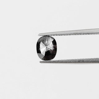 Cushion shaped salt and pepper diamond in tongs