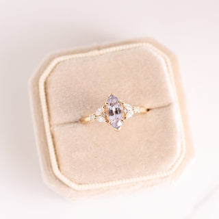 Yellow gold ring with purple gemstone and side diamond in a ring box