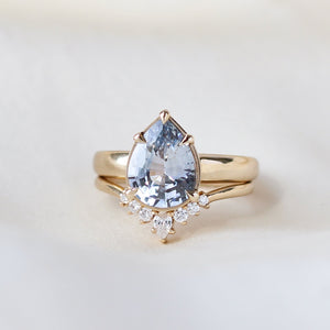 Pear pale blue sapphire engagement ring stacked with diamond gold band detail front view