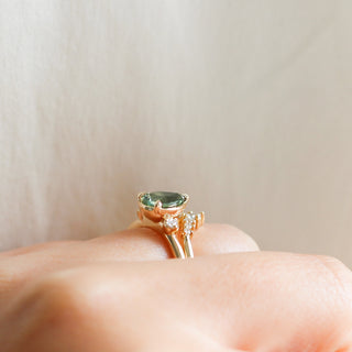 Pear cut green sapphire engagement ring on hand in profile