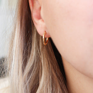 Tapered Gold Hoop Earrings worn on ear