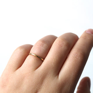 Hammered thin band in yellow gold, on hand