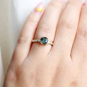 Rectangular cut green sapphire ring in yellow gold on hand