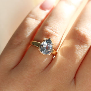 Pear pale blue sapphire engagement ring close up on hand