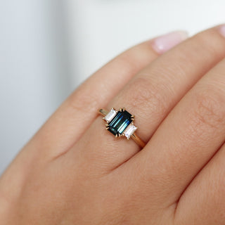 Emerald cut green teal sapphire engagement ring on hand
