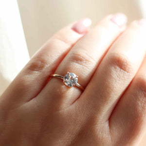 round white sapphire solitaire engagement ring on finger