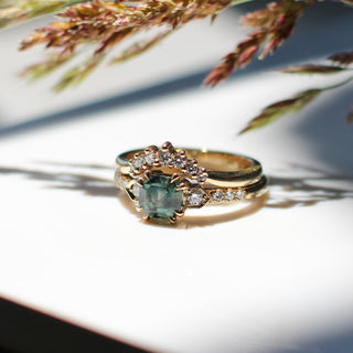 Cut Corner Rectangle Step Cut Green Sapphire Ring with diamond gold band and grains with reflections in sunlight
