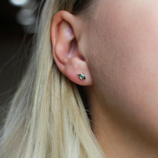 Marquise cut green sapphire earrings being worn