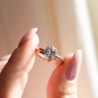 round white sapphire solitaire engagement ring held with matching band