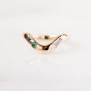 Custom thick wave wedding band with ethically sourced gemstones in a gold setting, handcrafted by Yuliya Chorna at her Toronto studio.