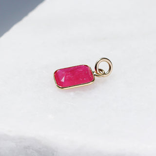 Large Ruby Bezel Charm quarter side view on marble 