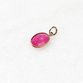 Large Ruby Bezel Charm detailed quarter view on marble 