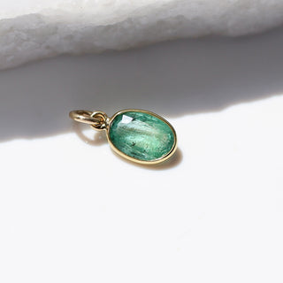 Large Emerald Bezel Charm detailed side view in sunlight with marble