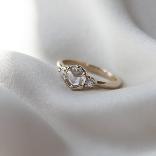 Custom engagement ring with ethically sourced white diamond centre stone in a gold setting, with accent diamonds.