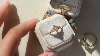 Marquise champagne diamond ring in a box held in the sunlight